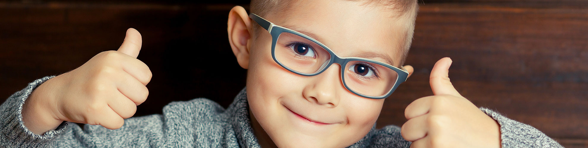 Young boy pediatric thumbs up wearing glasses
